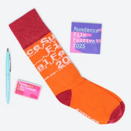 A collection of Sundance Film Festival 2025 merch: socks, a pen, a pin, a patch