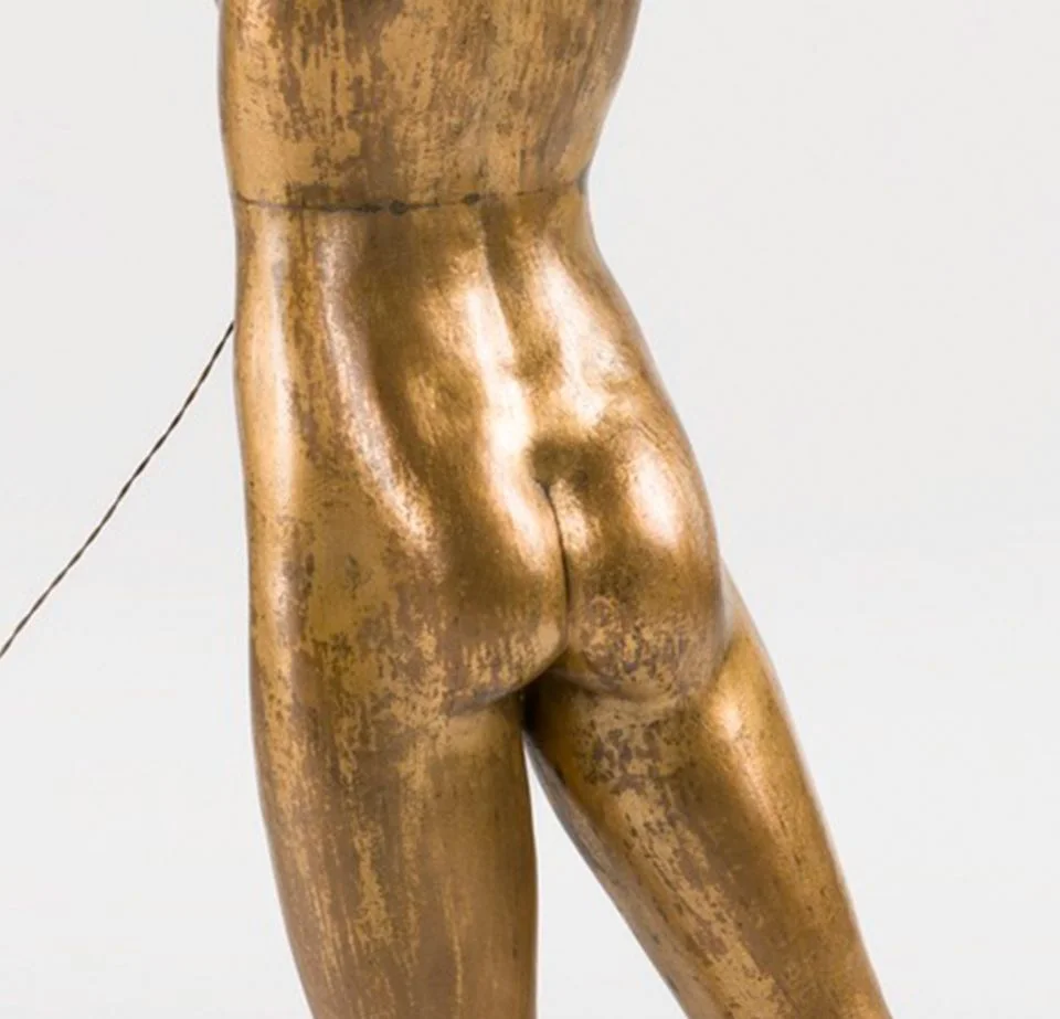 A close-up of the butt of a bronze statue