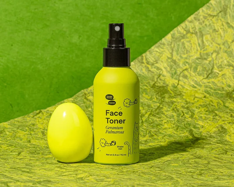 A lime green bottle sits next to a green egg against a green speckled backdrop