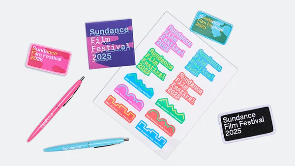 A collection of 2025 Sundance Film Festival merch: pens, patches, and stickers.