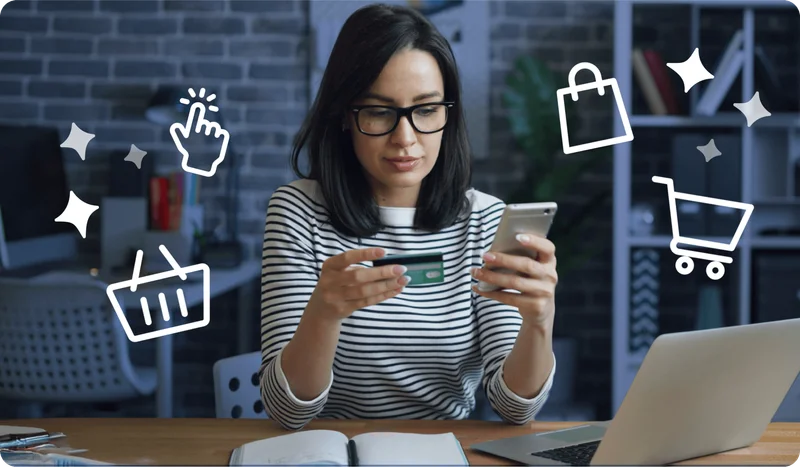 Image of woman holding a credit card in one hand and a phone in the other. Icons representing online shopping are around her, including a shopping cart, shopping basket, shopping bag and a mouse click.