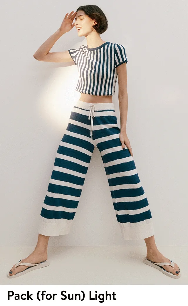 A model wearing a striped crop tee, wide-leg pull-on pants and sunglasses.
