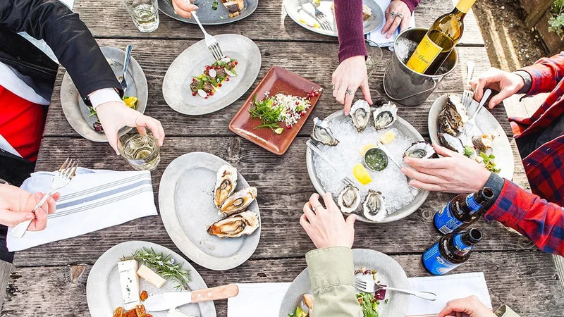 Image description: Overhead view of people dining at Hog Island Oyster Company’s Boat Oyster Bar in Marshall, CA.