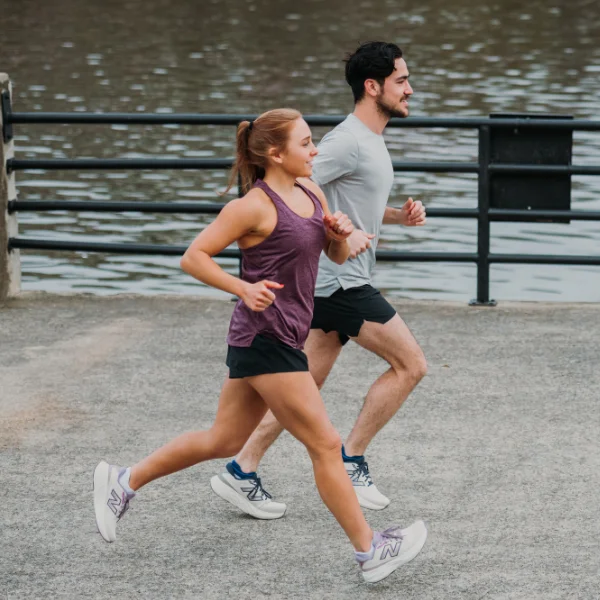 Man and woman running in New Balance shoes and gear