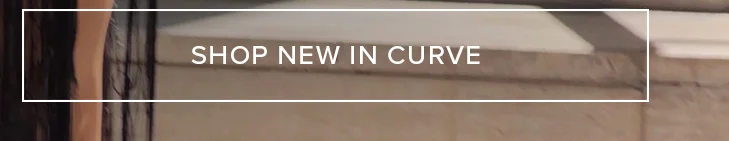 Muted brown and dark blurred background detail with white text 'SHOP NEW IN CURVE' prominently displayed. Shop new plus size clothing arrivals now.