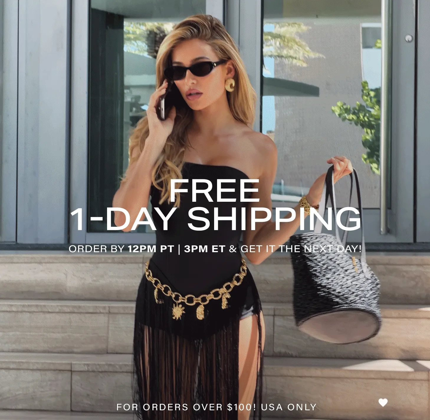 Stylish woman in black strapless outfit, gold chain belt, and sunglasses, holding a woven bag while talking on phone. Promotes free 1-day shipping on fashion.