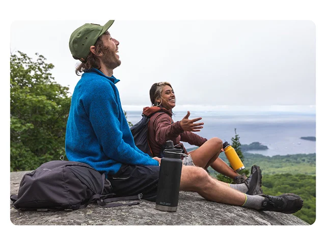 Two people on rock with water bottles
