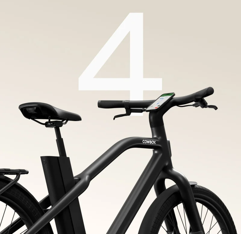 A close-up of a Cowboy bike’s handlebars and saddle with the number “4” prominently displayed in the background, showcasing the minimalist design.