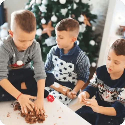 three brothers doing holiday baking with a christmas tree in the background three brothers doing holiday baking with a christmas tree in the background