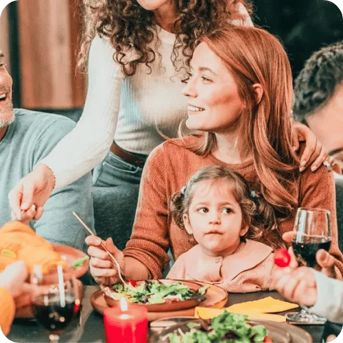 a mother with a mischievous looking toddler on her lap at a holiday meal a mother with a mischievous looking toddler on her lap at a holiday meal