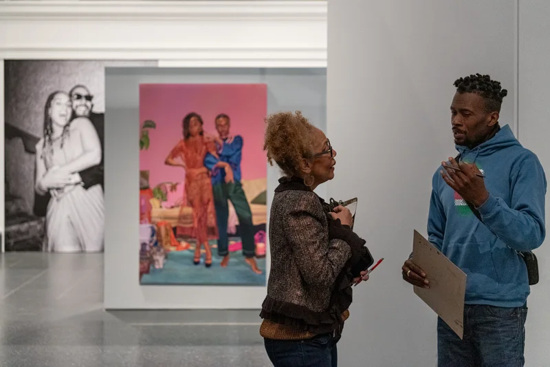 Two people speaking in an art gallery