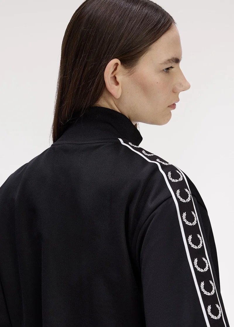 Woman wearing our classic women's black taped track jacket