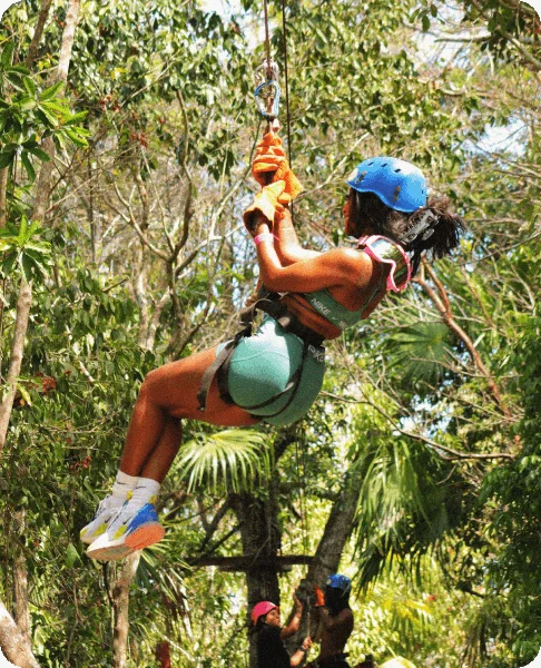 Image Description: A female traveler zip-lining through a tropical jungle on an outdoor adventure tour in Mexico