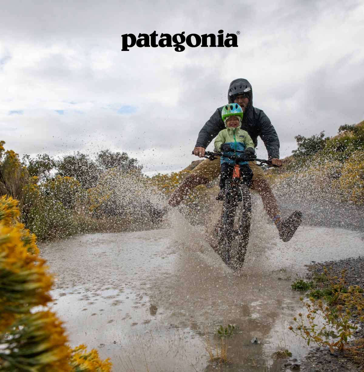 Patagonia. A man rides his bike through a puddle with his kid on the handlebars.