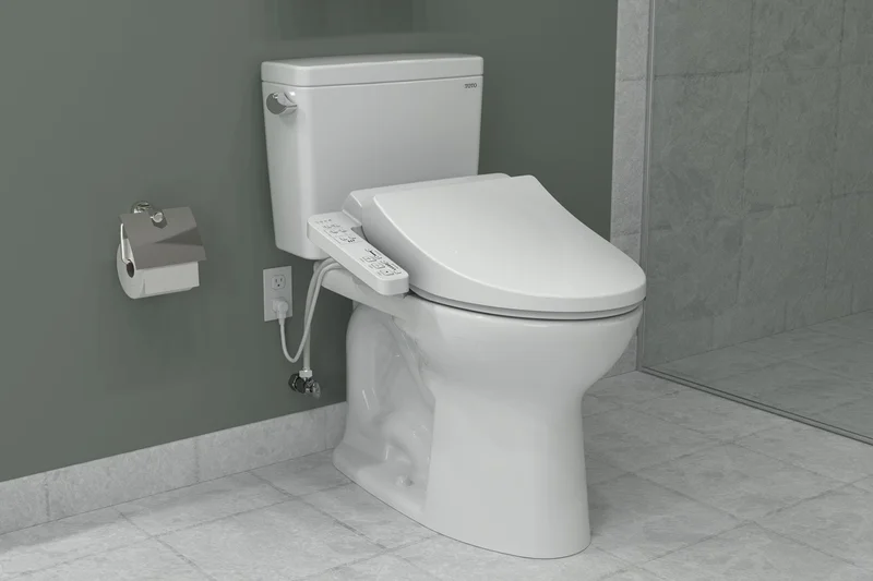 A TOTO A2 WASHLET in a bathroom with a gray stone tile floor and a glass door shower