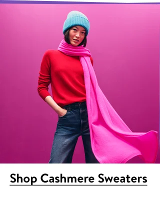 A woman wearing a scarf, sweater and beanie.