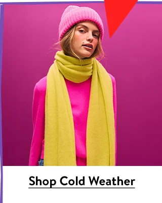 A woman wearing a scarf, sweater and beanie.