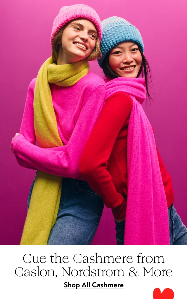 Two women wearing scarves, sweaters and beanies.