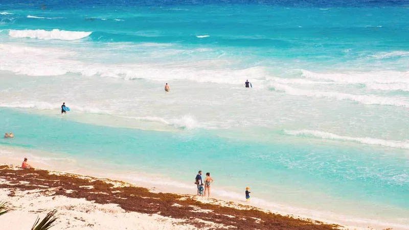 Image description: Tourists enjoy the beach, Playa Caracol, on Isla Mujeres.