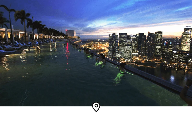 Image Description: Travelers admiring the Singapore skyline at dusk from the massive infinity pool atop Marina Bay Sands
