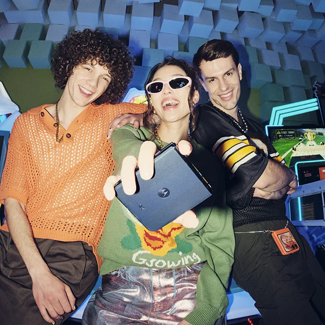 Three people with, one holding the new motorola razr+ 2024