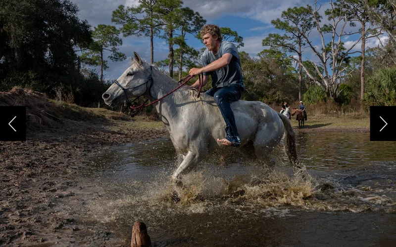Ethan Warren and his cracker horse Monty, surge up the banks after swimming across a water hole for fun on the second to last day.