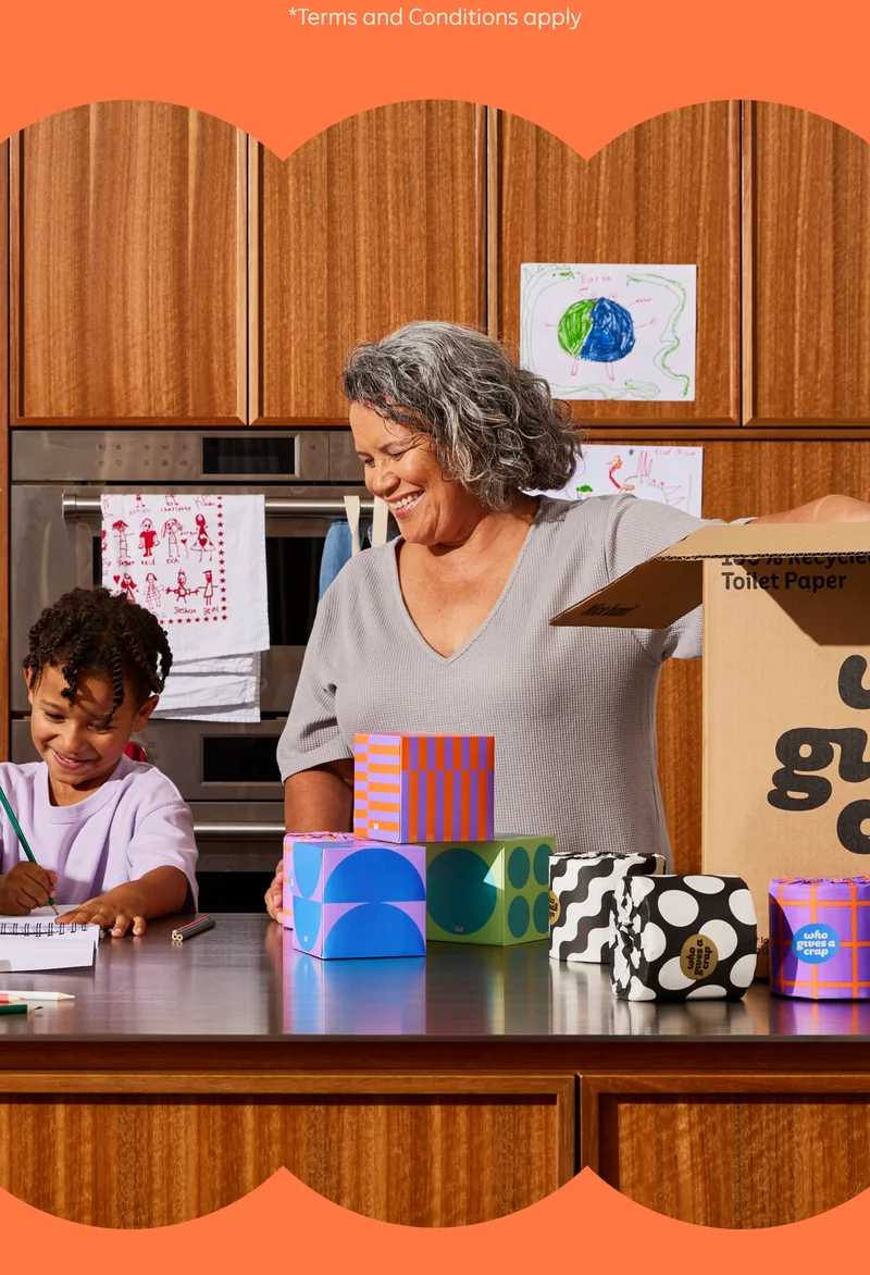 *Terms and Conditions apply. Image: Mom and son smiling in the kitchen with Who Gives A Crap tissues and toilet paper on the counter