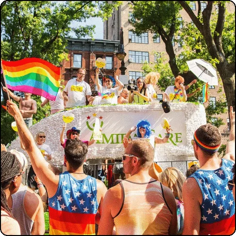 Image Description: Pride parade float and people on the side celebrating.
