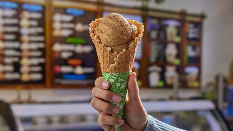 Waffle cone filled with Ben & Jerry's Honey Graham Latte ice cream. Scoop Shop setting.