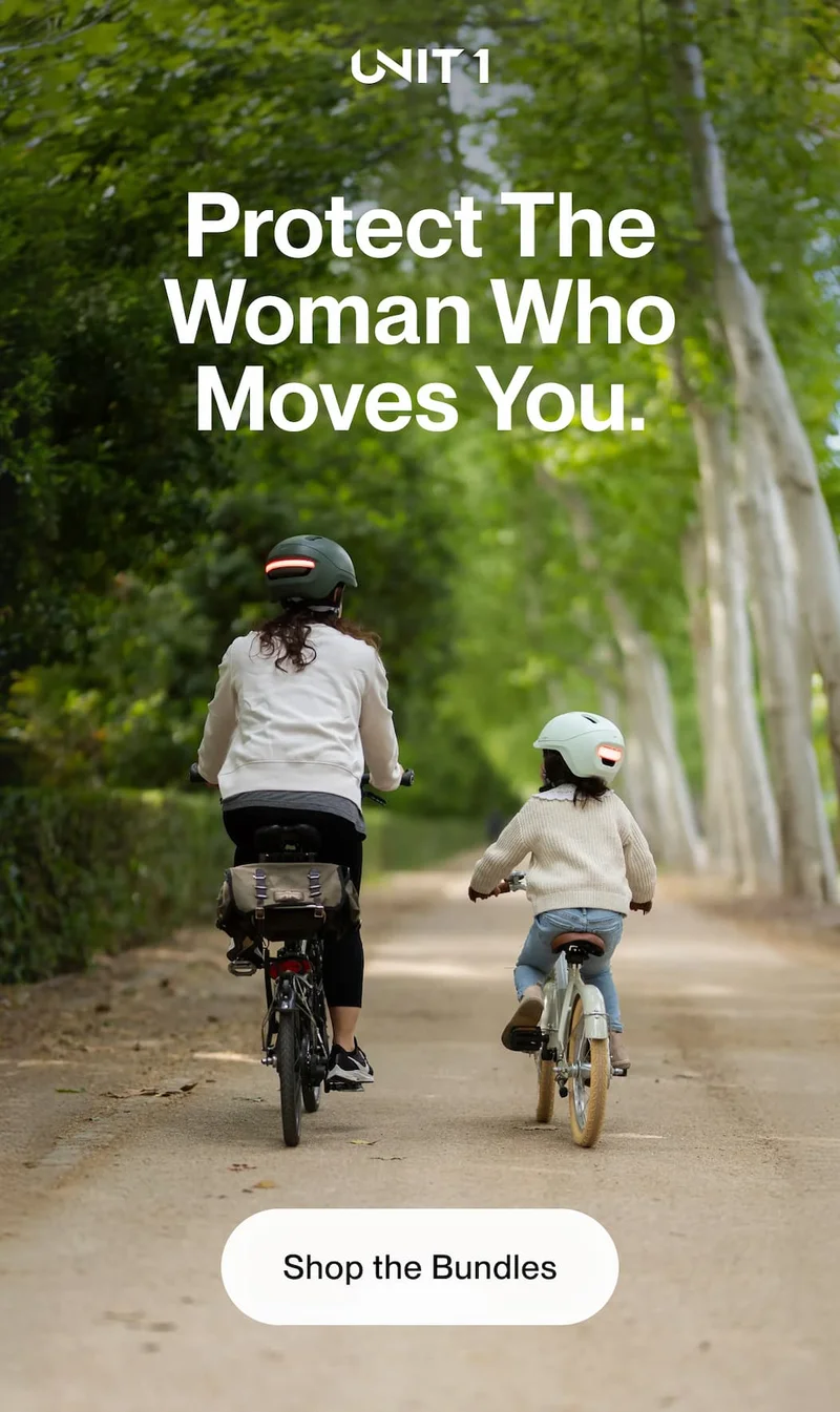 Woman and young child riding bikes on a tree-lined path, both wearing Unit 1 helmets — Protect The Woman Who Moves You.