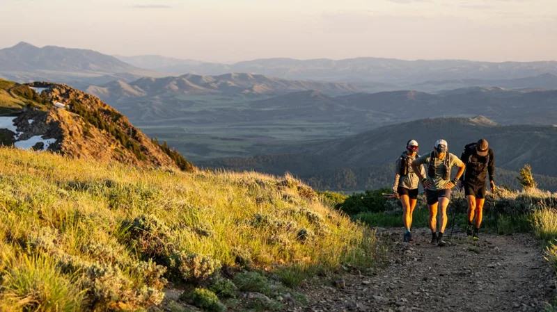 Three trail runners walking together at elevation.