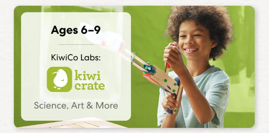 Young girl smiling while working on a science experiment from KiwiCo Labs. Hands-on STEM learning for ages 6–8.