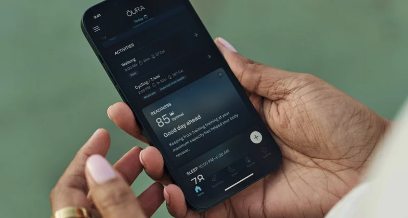 Hands holding phone with Oura app open