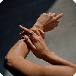 Right hand touching arm wearing Oura Ring