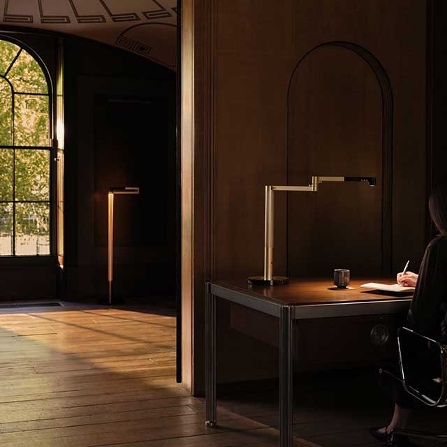 Owner sat at her desk doing work with the Dyson Solarcycle Morph desk light.