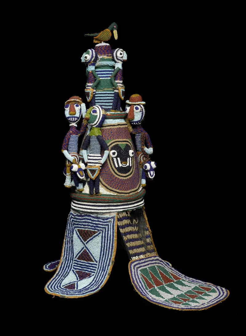 large crown made with colorful beads, small human figures decorated on top