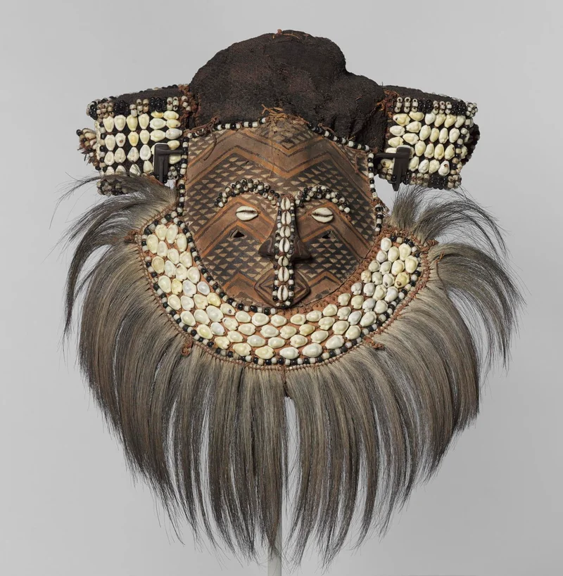 mask with white shells decorated as facial features and grey-ish hair attached