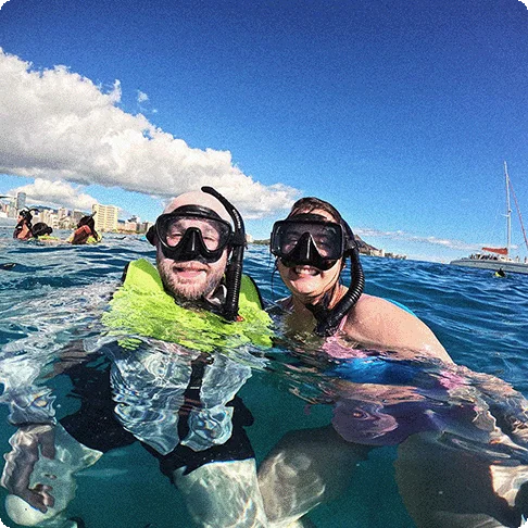 Image Descriptions: A historical building with a statue in front surrounded by palm trees and an image of two people snorkeling.