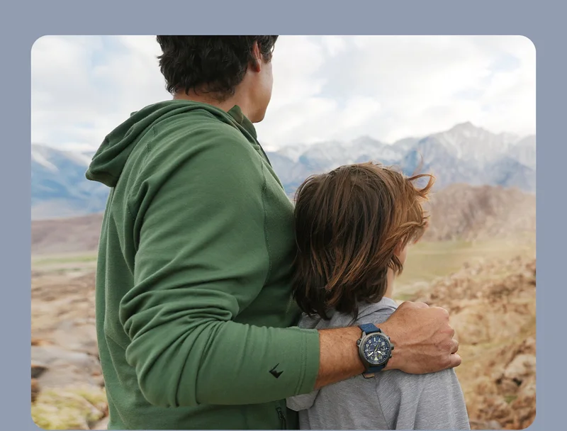 A father embraces his son, while taking in the breathtaking landscape on their hike.