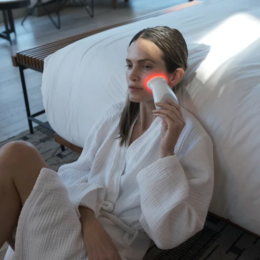 Woman holding Trinity with Wrinkle Reducer attachment on cheek