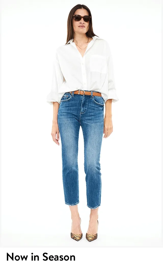 A woman wearing white button-up shirt and blue jeans.