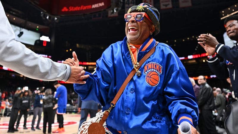 Image may contain: Spike Lee, Face, Head, Person, Happy, Adult, Baby, Accessories, Bag, and Handbag