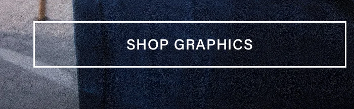 White 'SHOP GRAPHICS' button centered on a textured dark blue fabric and light gray concrete background, directing to graphic apparel.