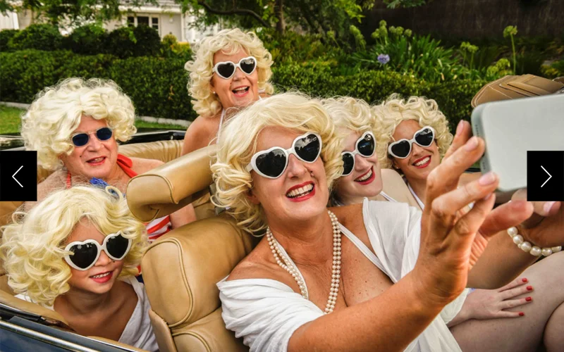 A handful of Marilyn Monroe impersonators in a convertible taking a selfie