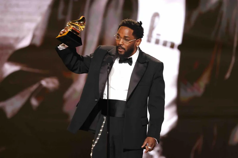 Image may contain: Kendrick Lamar, Clothing, Formal Wear, Suit, Adult, Person, Performer, Solo Performance, Face, and Head