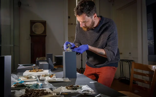 A researcher examines objects from the Melsonby Hoard.