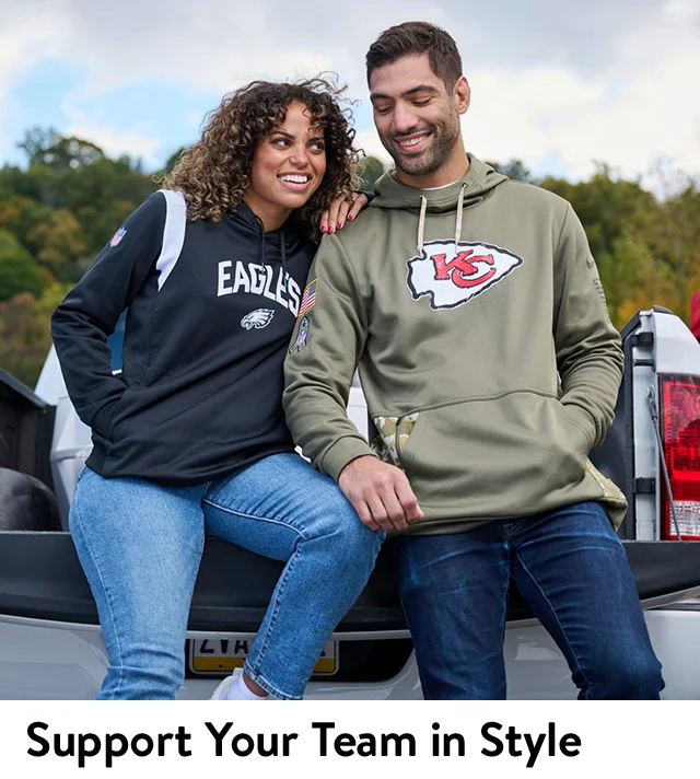 A woman and man wearing sweatshirts featuring team logos.
