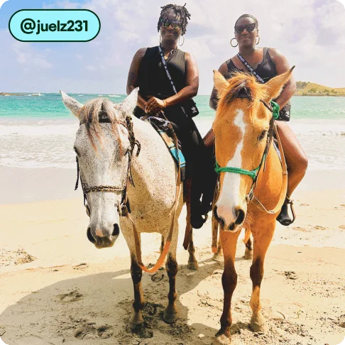 Image Description: Two people riding horses on a beach.