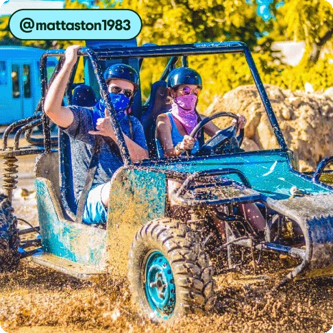 Image Description: Two people driving a buggy through the mud.