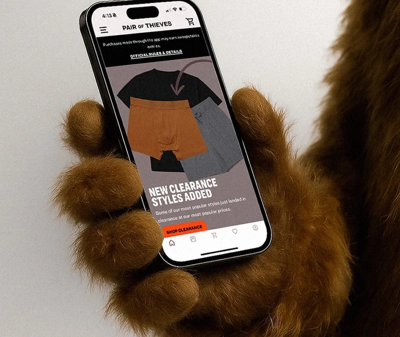 Image of a bear using the Pair of Thieves app on a phone.